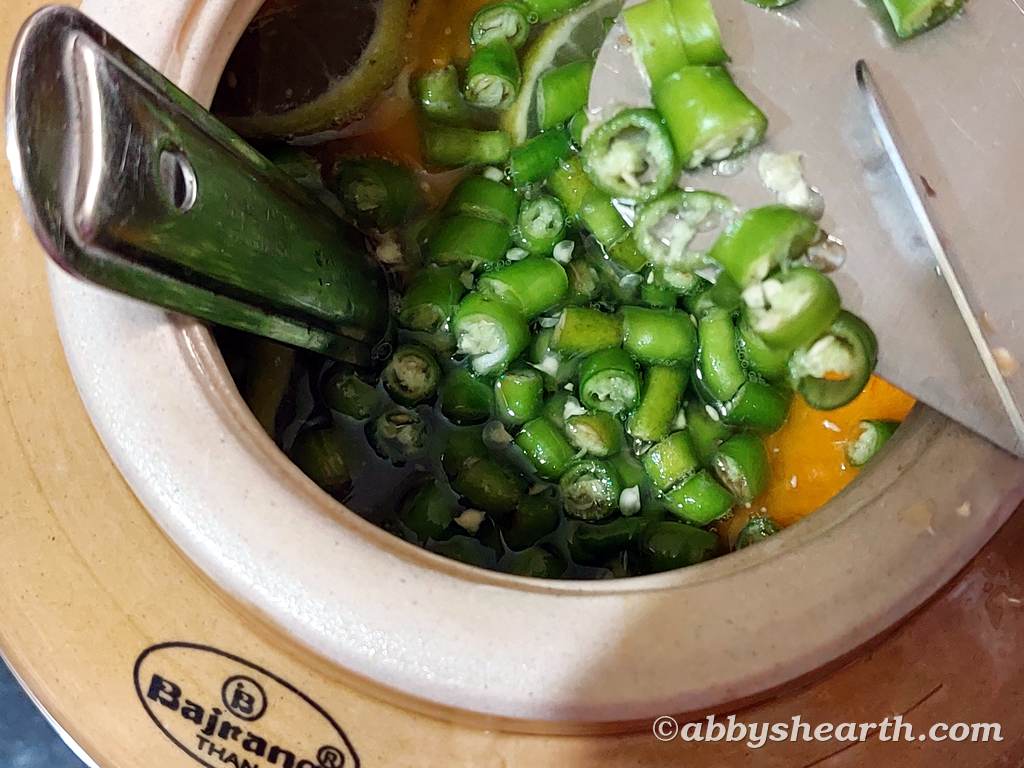 Chopped green chillies in a ceramic bowl for homemade mango wine recipe.
