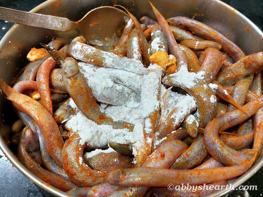 Raw kalentas with seasoning and rice flour in a steel pot, ready for cooking.