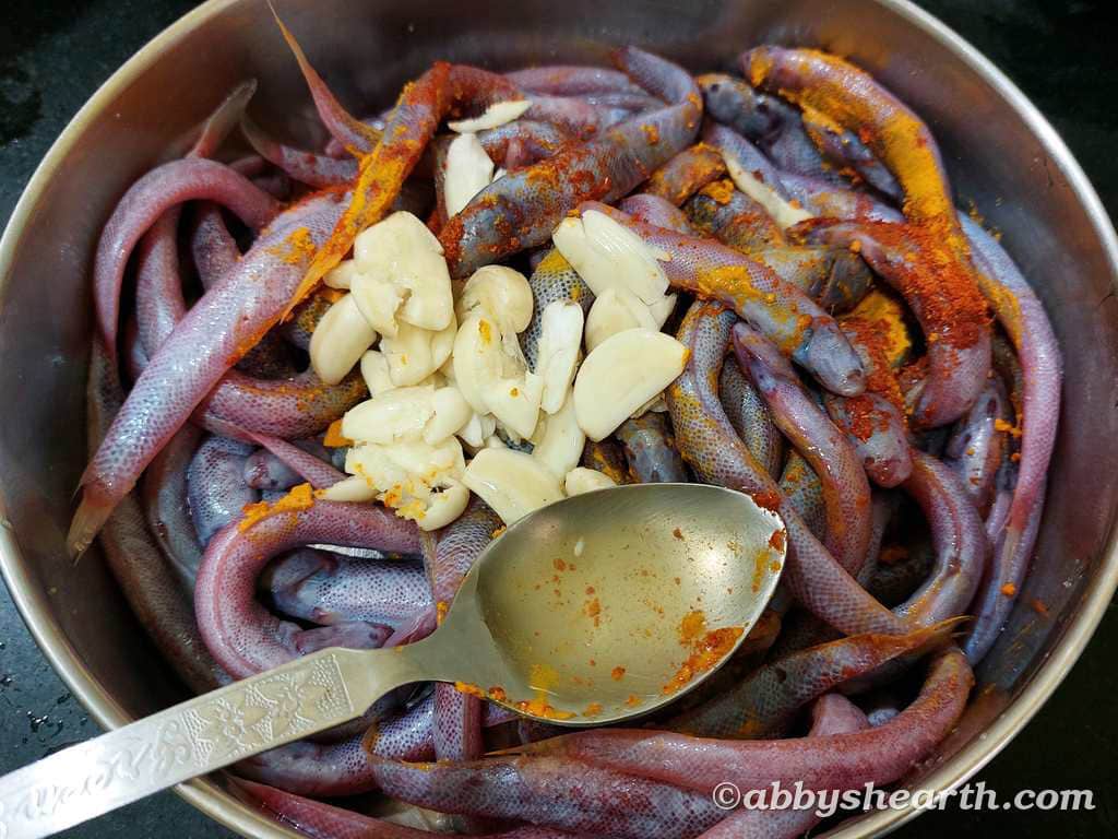 Kalentas with spices and garlic cloves in a steel pot.
