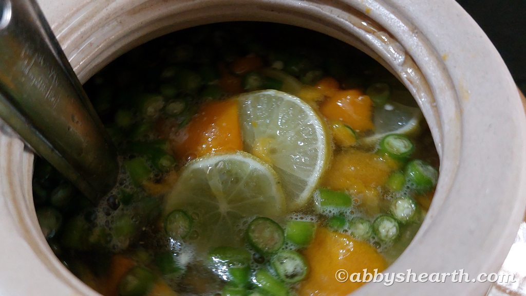 Add slices of green chillies and lemons to the mango wine must.