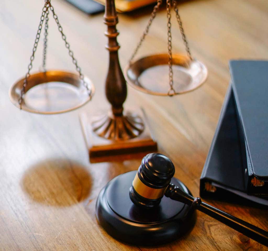 A judges gavel and scales on a desktop.