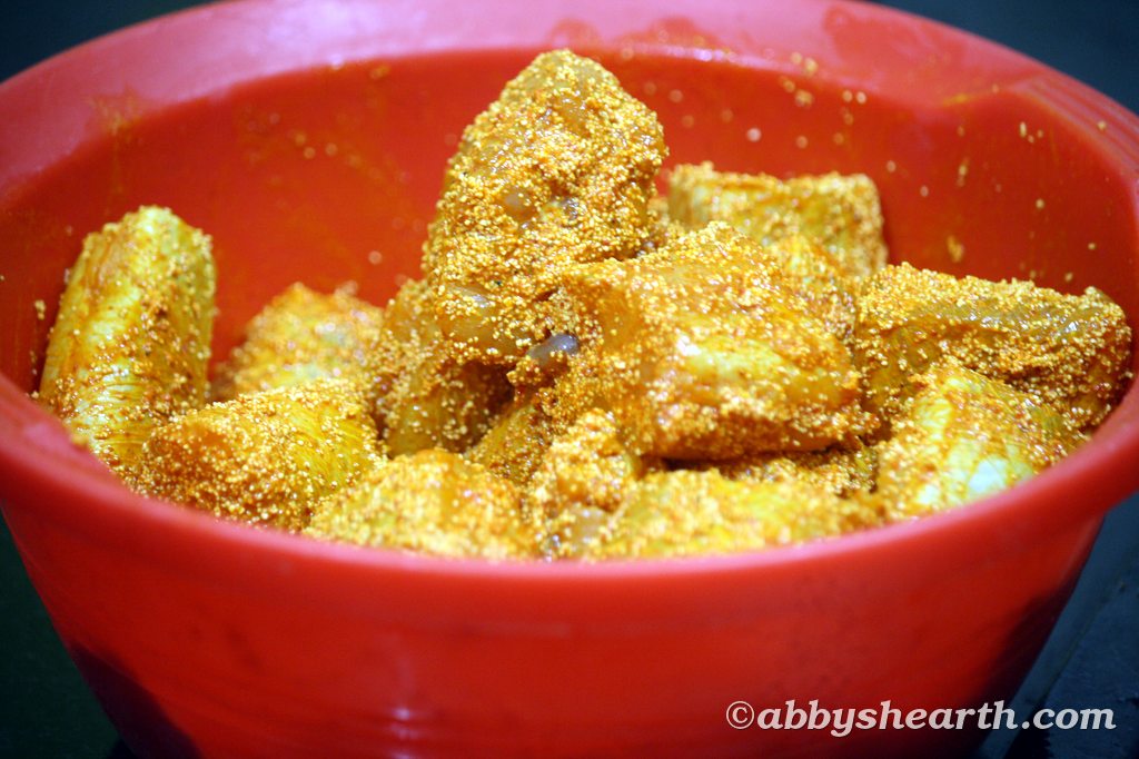 Marinated shark fish pieces in a red bowl mixed with semolina.