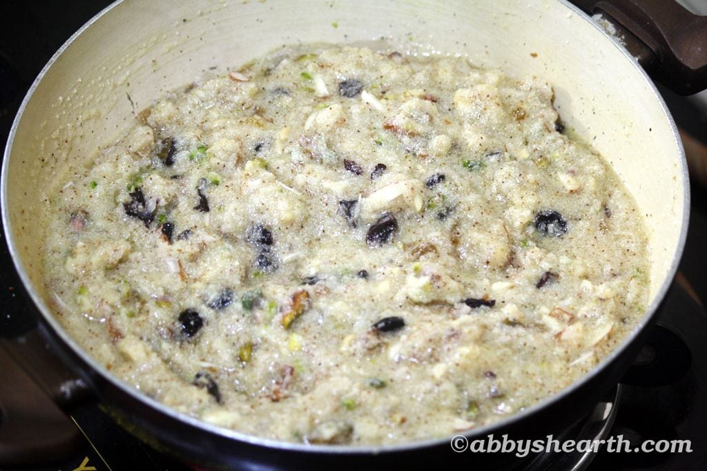 Close-up of semolina halwa with nuts cooking in a pan for Sojee Halwa recipe.