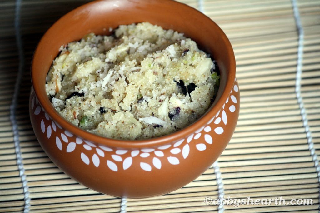 Soft semolina halwa with nuts served in a clay pot on a bamboo mat.