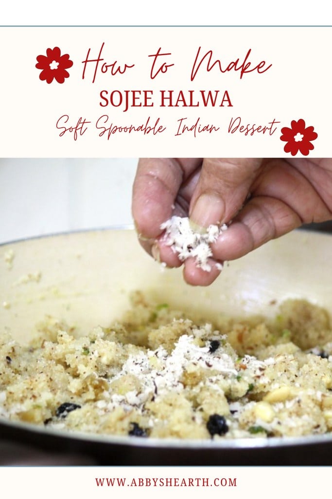 Close-up of a hand garnishing Sojee Halwa with shredded coconut.