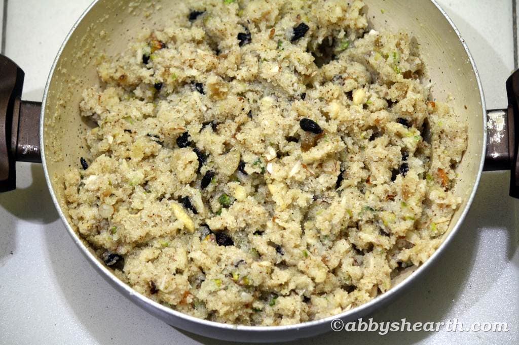 Close-up of soft semolina halwa with nuts and raisins in a pot.