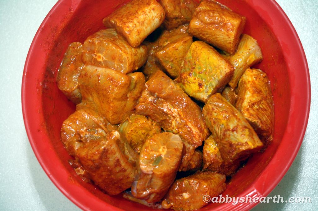 Shark fish pieces in a red bowl marinating with spices.