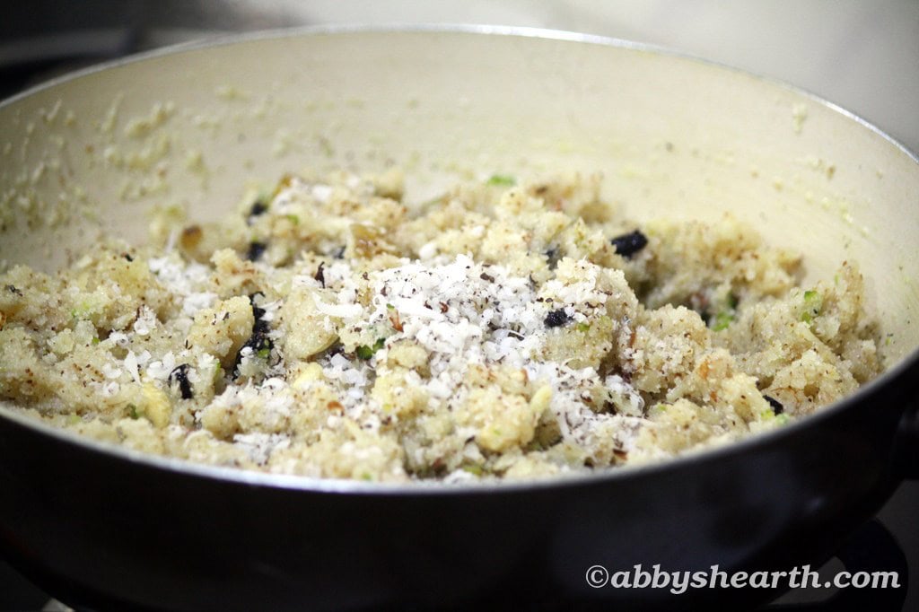 Close-up of soft semolina halwa with nuts and grated coconut on top.