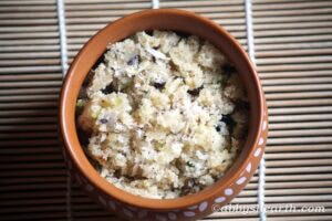 Soft semolina halwa with nuts served in a brown bowl on a bamboo mat.