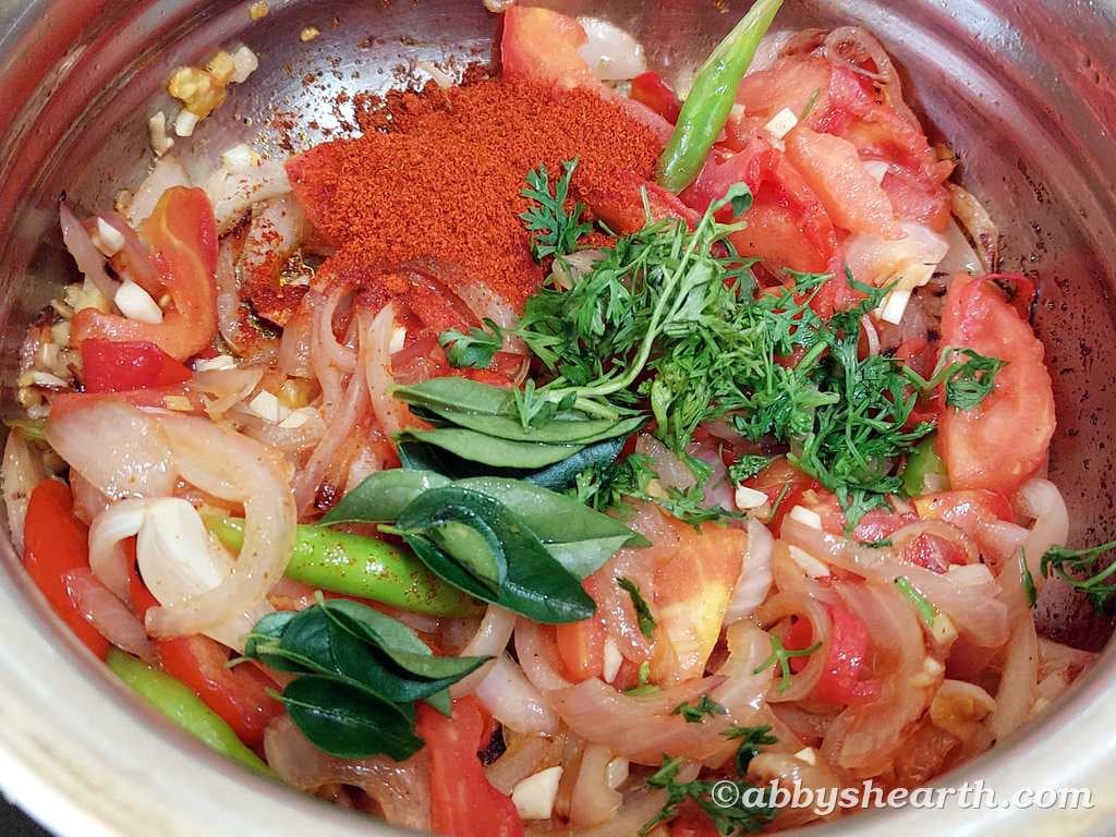 Fresh chopped tomatoes, onions, and more in a cooking pot for chicken liver stir fry.