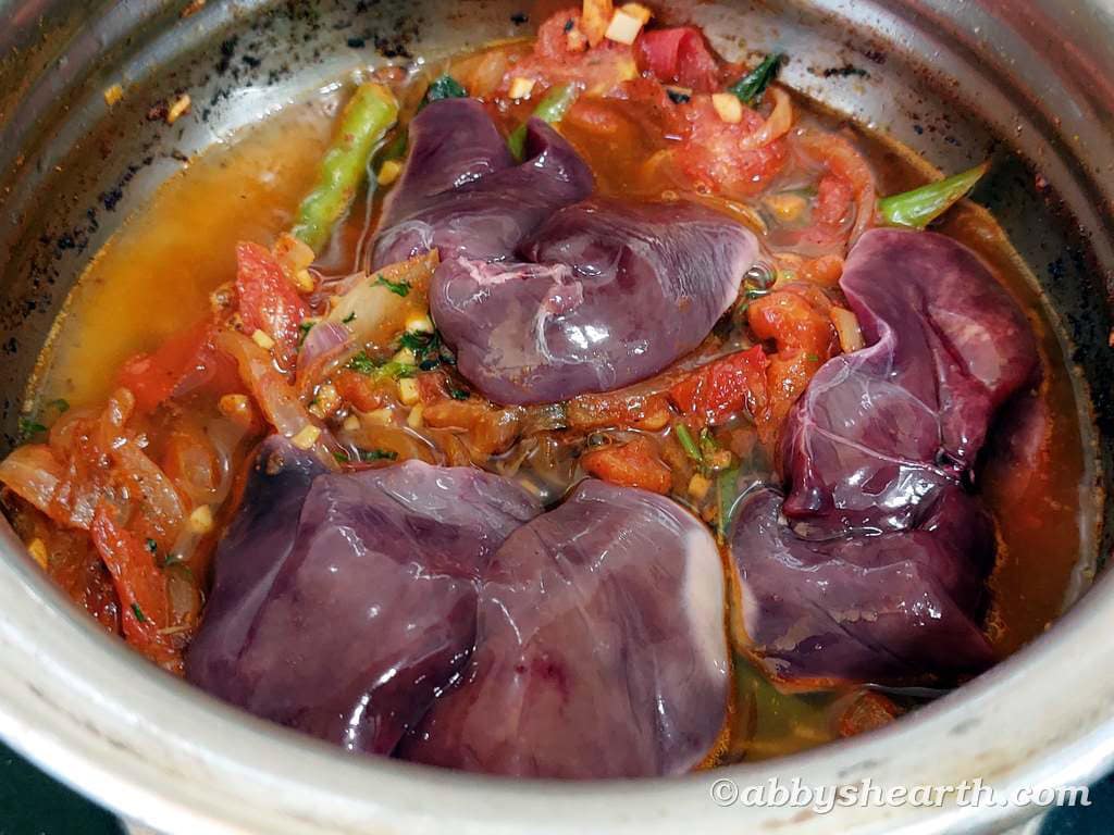 Cooking chicken liver stir fry with vegetables in a pot for a flavorful meal.