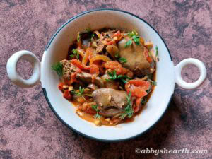 Chicken liver stir fry with vegetables in a white bowl.