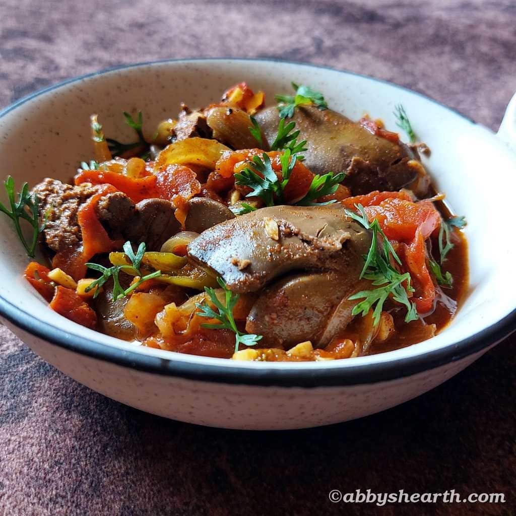 Chicken liver stir fry in a white bowl.