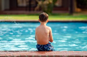 Child sitting on the edge of pool.