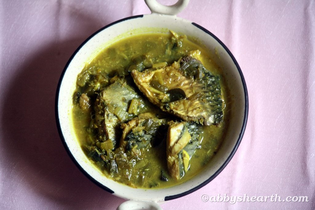 Green curry of palla/hilsa/illish fish in a beige dish.