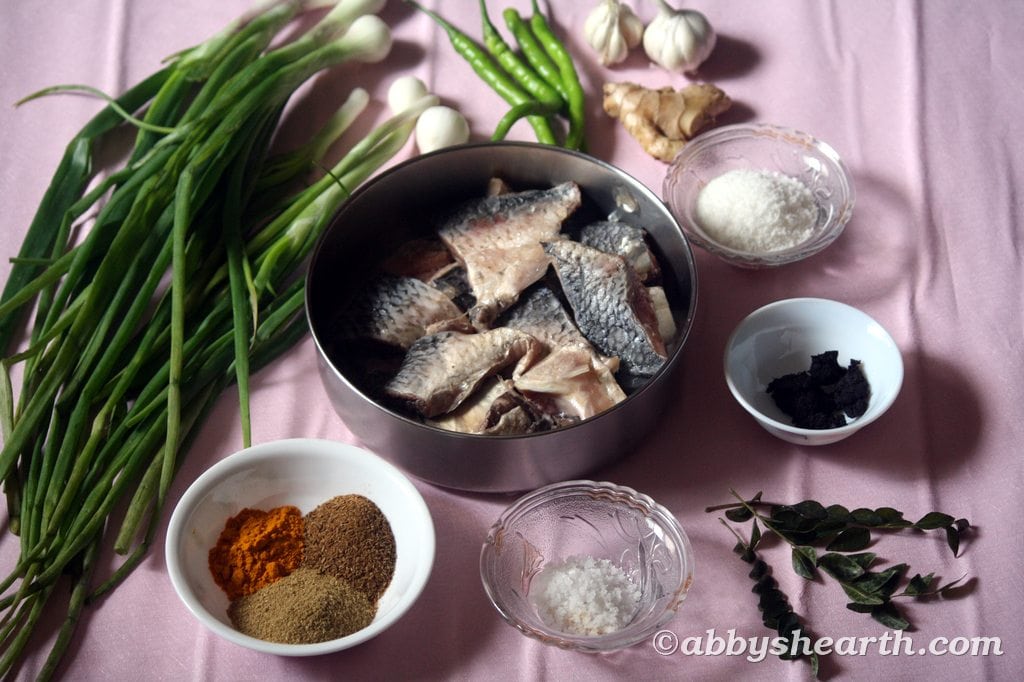 Ingredients for palla khujit curry on a pink sheet.