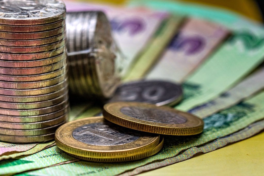 Stack of coins and paper currency representing financial stewardship and wealth.