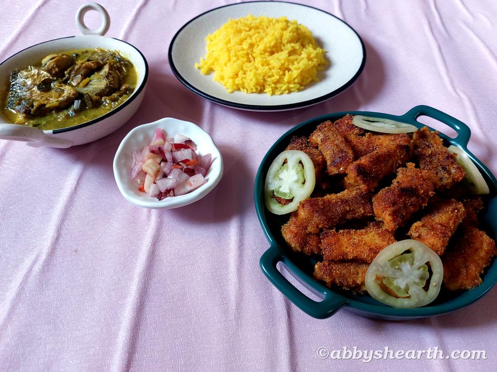 Palla curry served with rice, salad and fish fingers.