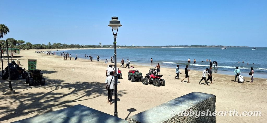 Scenic Nagoa Beach scene with tourists and ATVs for rides.