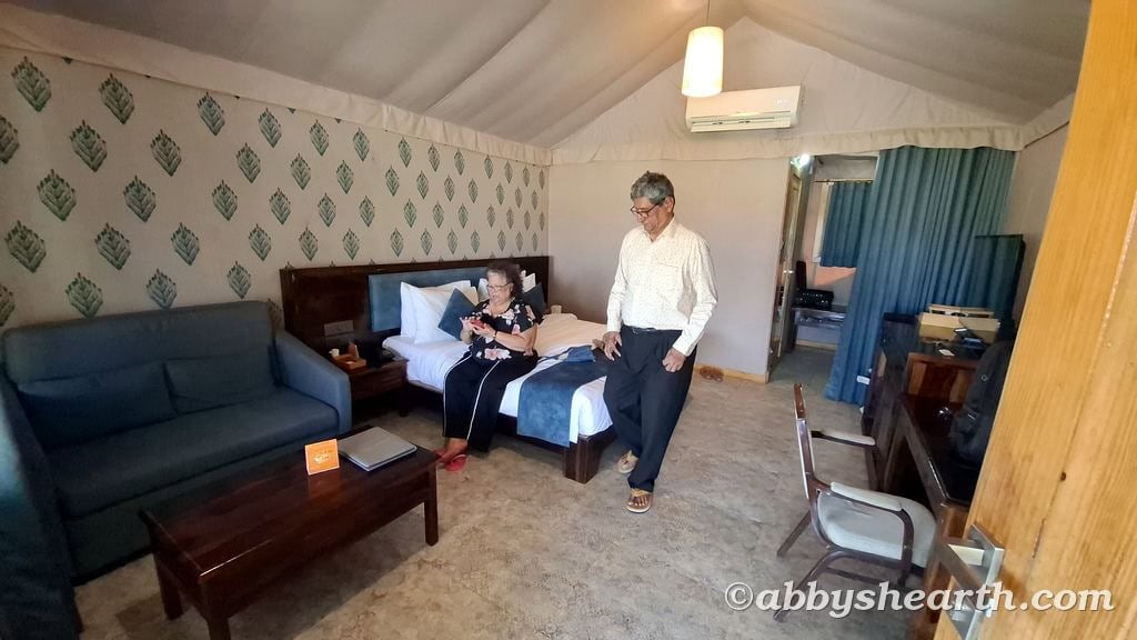 My parents relaxing in a cozy hotel room with patterned wallpaper and modern decor.