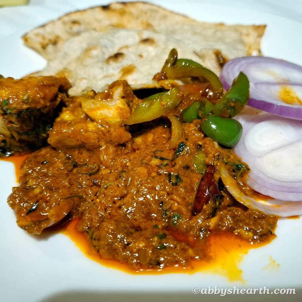 Spicy Indian chicken curry with green peppers, onions, and flatbread.
