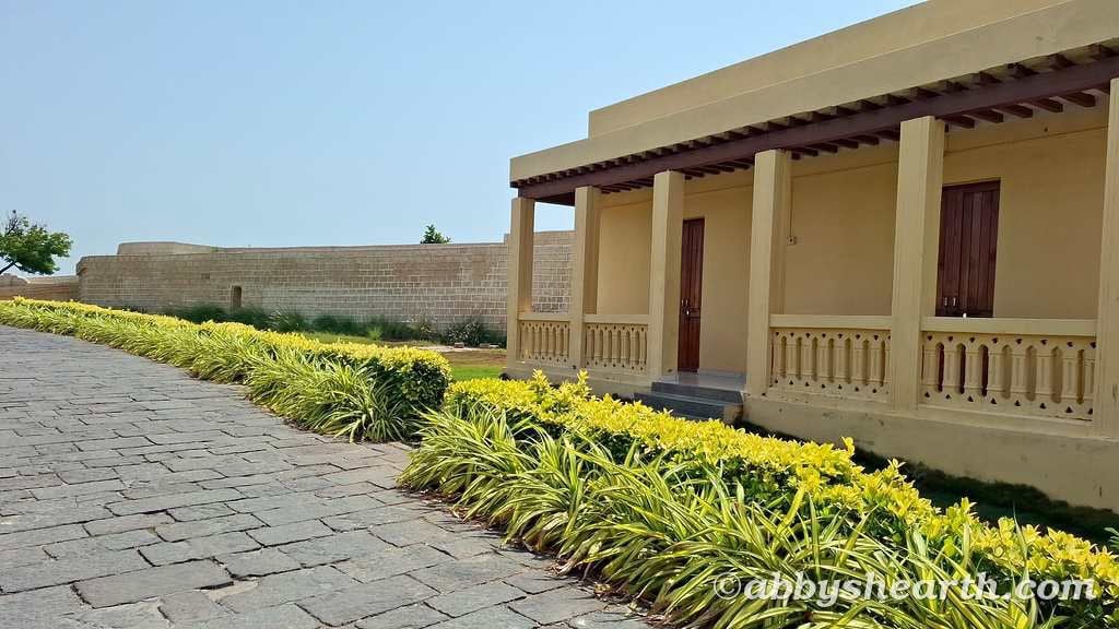 Inside historic Diu fort  with a garden path and traditional architecture.