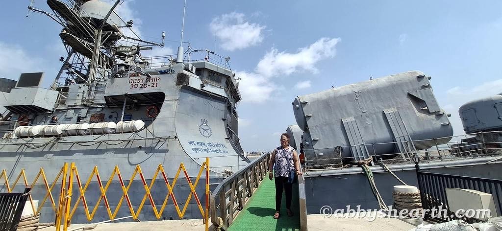 Mom walking out from the Khukri ship deck in Diu with slogan in the background.