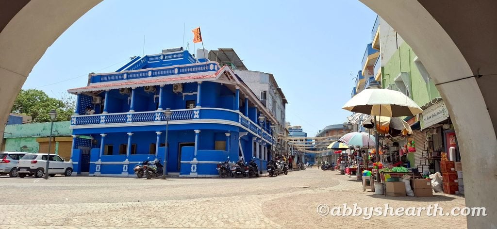 Vibrant blue building with balconies in Diu, India, under a clear sky.