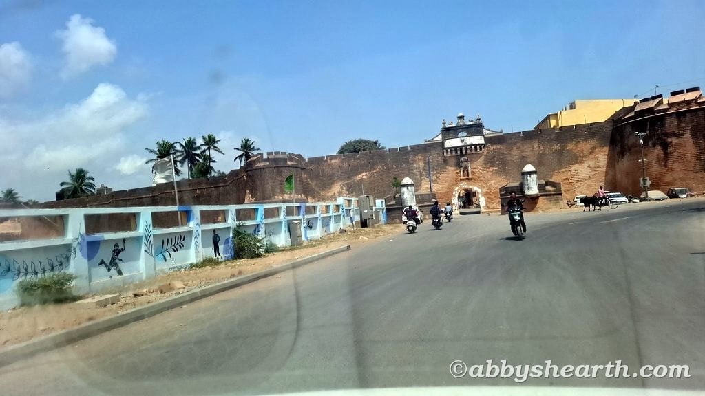 View of Zampa Gateway in Diu with motorcycles and blue sky.